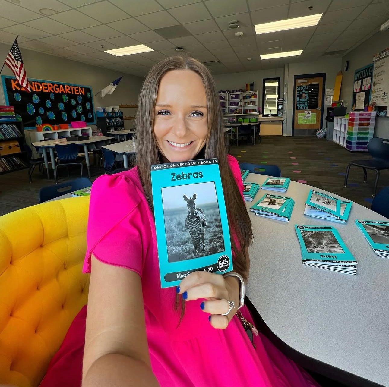 Teacher holding a book titled 'Zebras' in a classroom setting